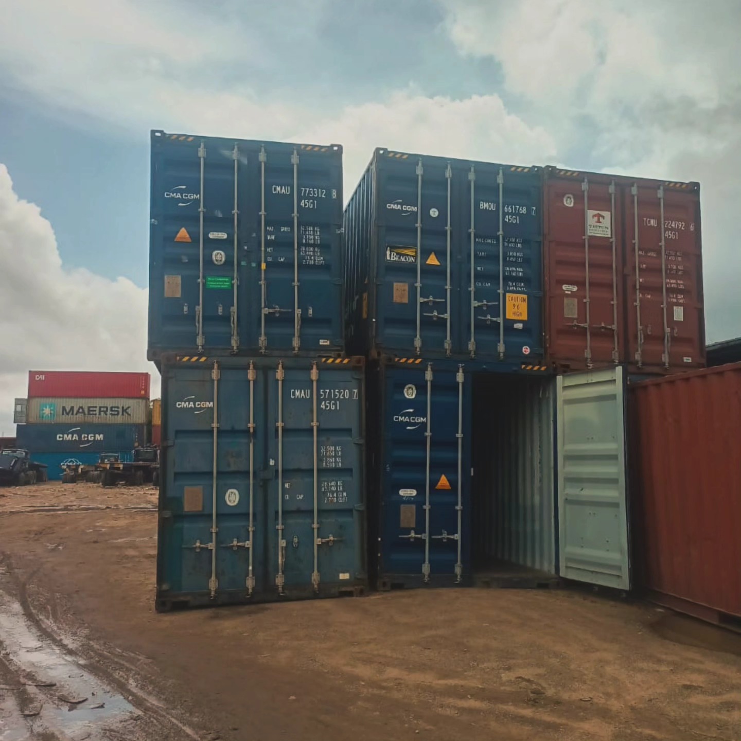 Stacked CMA CGM and Maersk containers at terminal